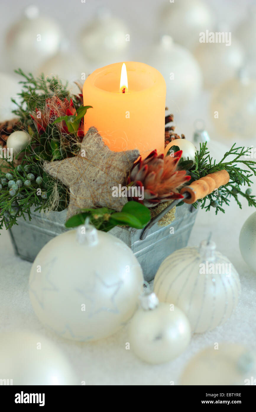 Christmas floral arrangement with candle and Christmas baubles Stock Photo