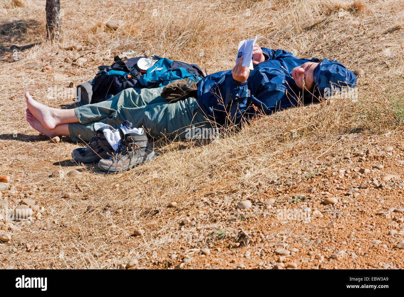 female pilgrim having a break at the border of the Way of St James, Spain, Kastilien und Le¾n, Palencia, Calzadilla de la Cueza Stock Photo