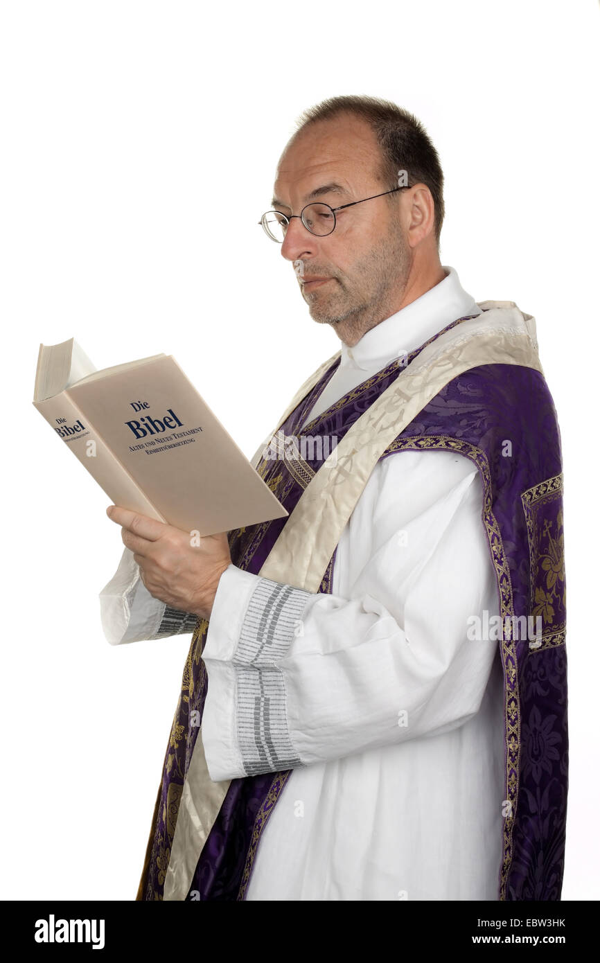 catholic priest reading in the bible Stock Photo