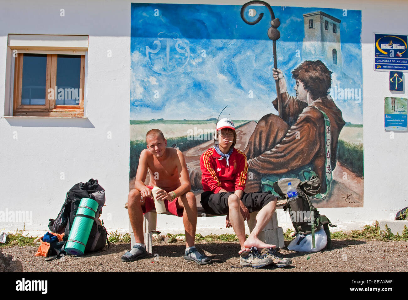 two young pilgrims in front of a mural painting, Spain, Kastilien & Le¾n, Palencia, Calzadilla de la Cueza Stock Photo