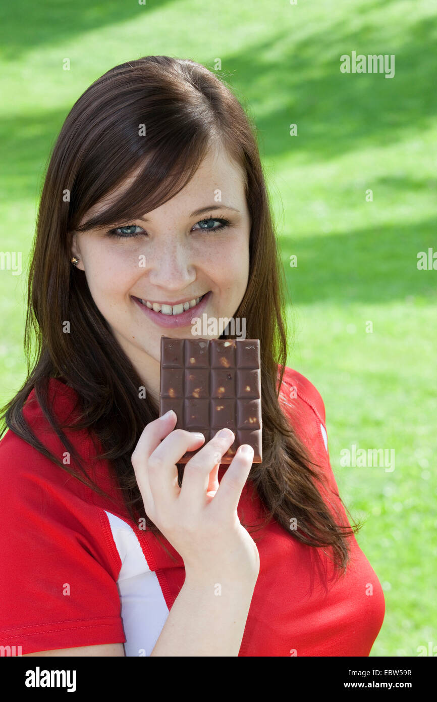 brunette-haired young woman with a bar of chocolate, Germany Stock Photo