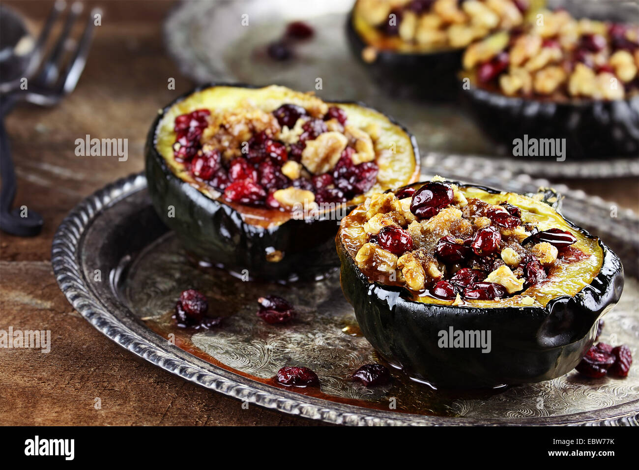 Acorn squash stuffed and baked with butter, brown sugar, walnuts and cranberries, ready for holiday dinners. Stock Photo