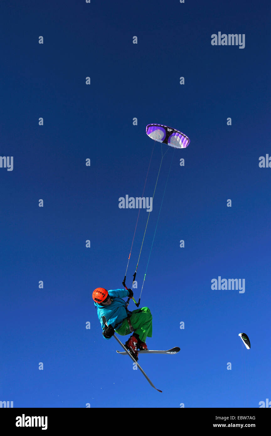 man floating in front of clear blue sky paragliding with skis, France Stock Photo