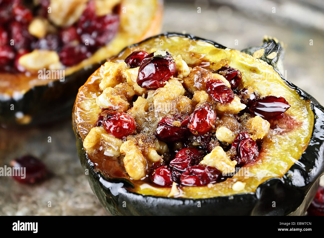 Acorn squash stuffed and baked with brown sugar, walnuts and cranberries, ready for holiday dinners. Stock Photo