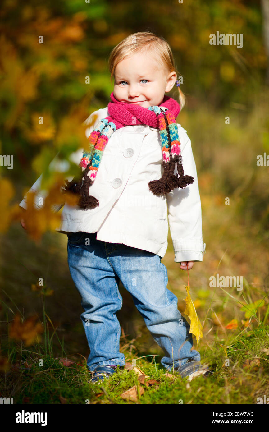 little girl with scarf holding autumn leaf Stock Photo - Alamy