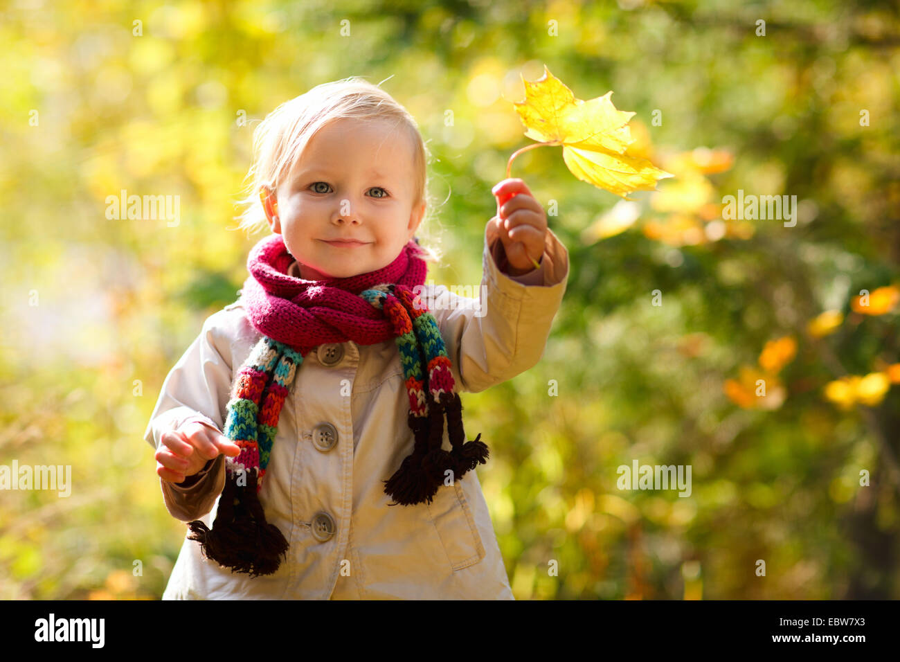 little girl with scarf holding autumn leaf Stock Photo - Alamy