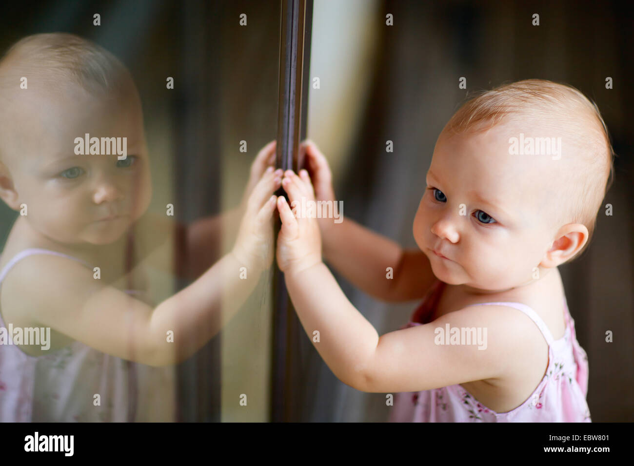 a little girl standing in front of a glass door Stock Photo - Alamy