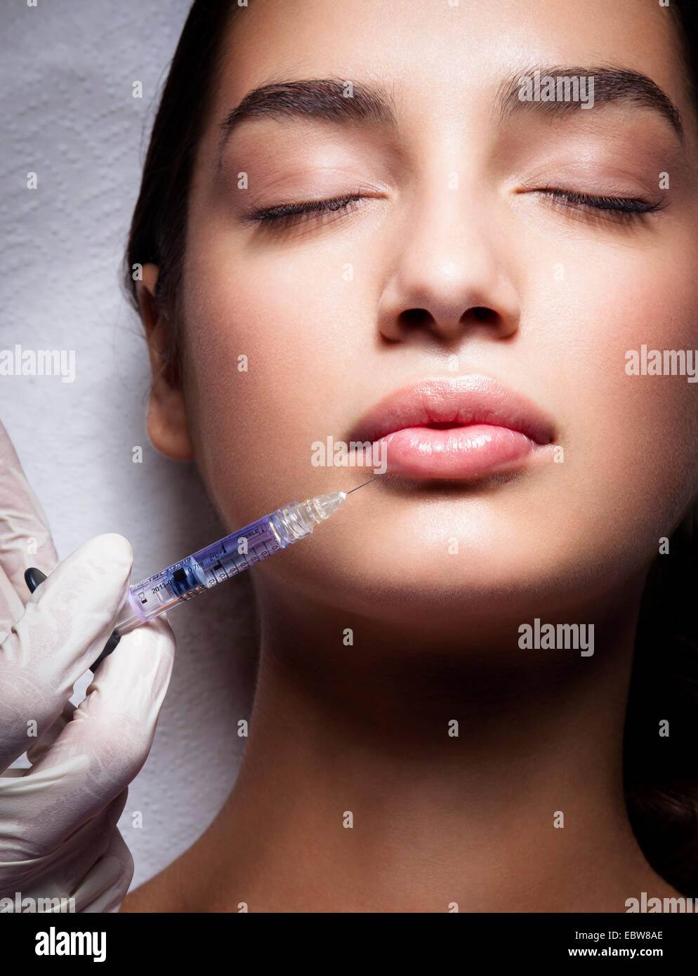 Young woman getting a lip filler. Hyaluronic acid treatment. Stock Photo