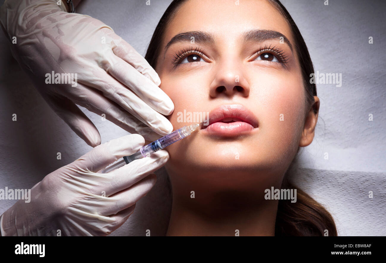 Young woman getting a lip filler. Hyaluronic acid treatment. Stock Photo