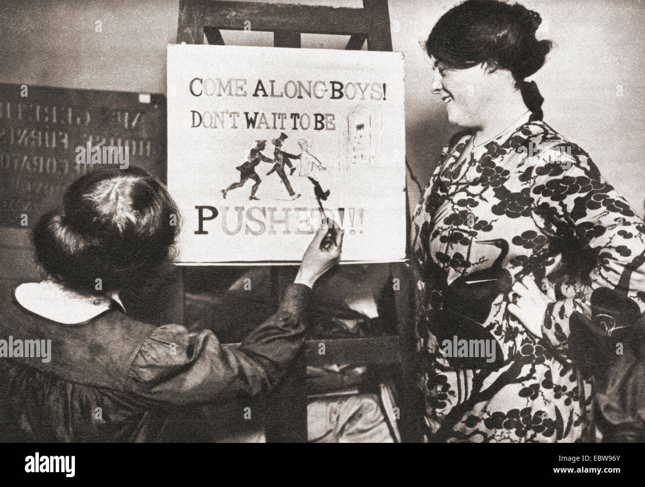 A young girl during World War One painting a recruitment poster which reads ' Come along boys, don't wait to be pushed' Stock Photo