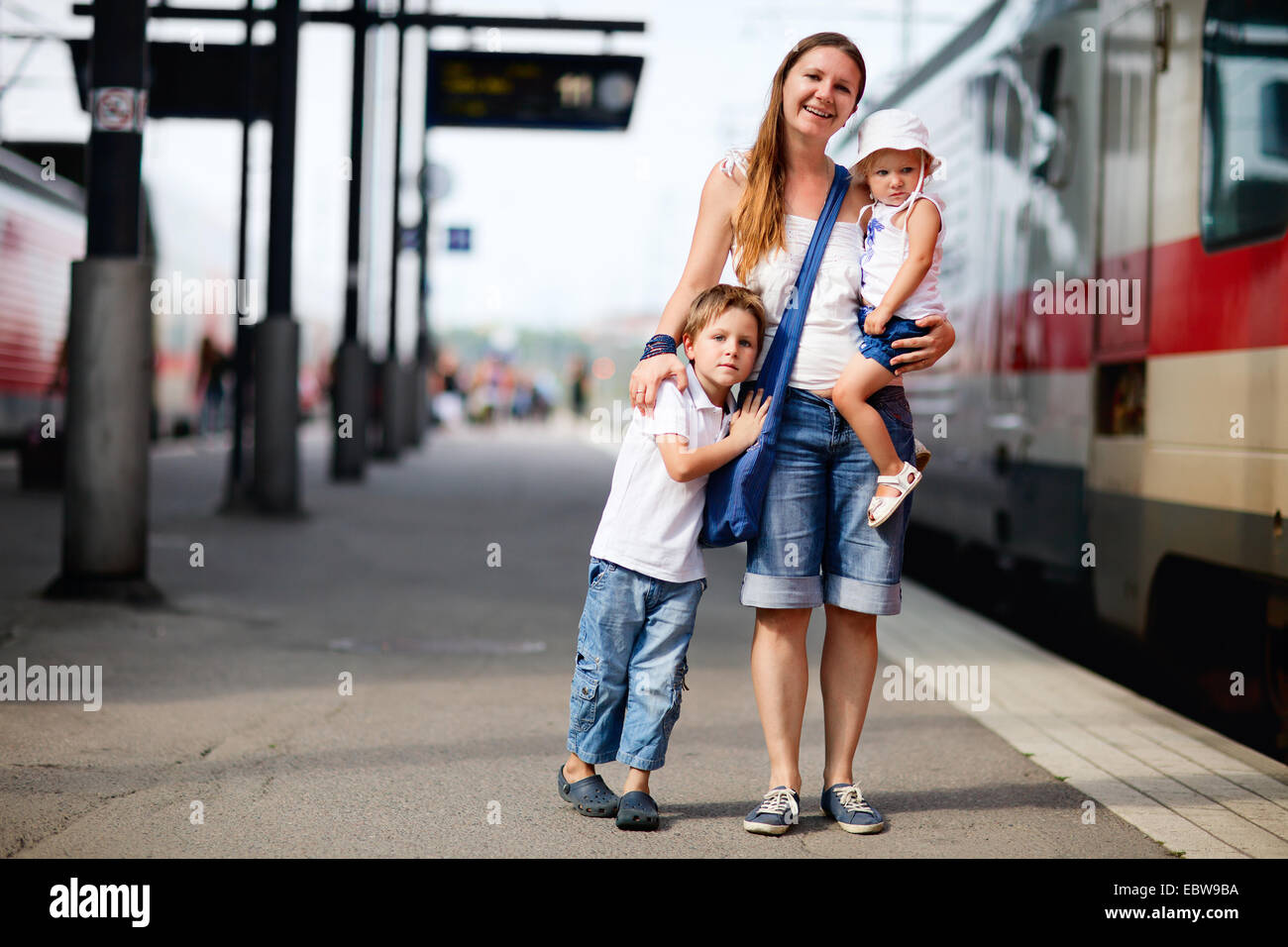 a young mother with her two children waiting for train Stock Photo