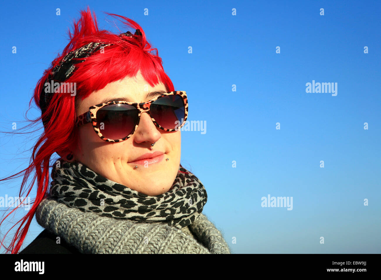 portrait of a young woman with eye-catching sunglases and the hair tinted pink Stock Photo