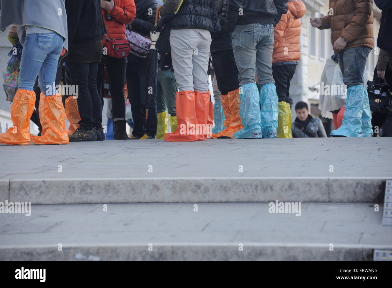 tourists wearing plastic shoes in venice acqua alta Stock Photo Alamy