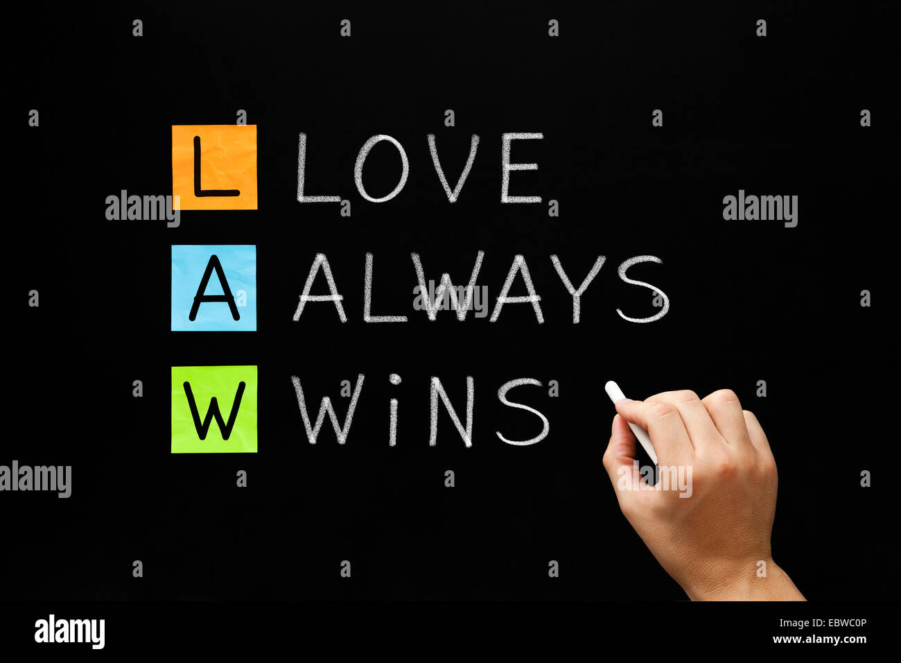 Hand writing LAW - Love Always Wins with white chalk on blackboard. Stock Photo
