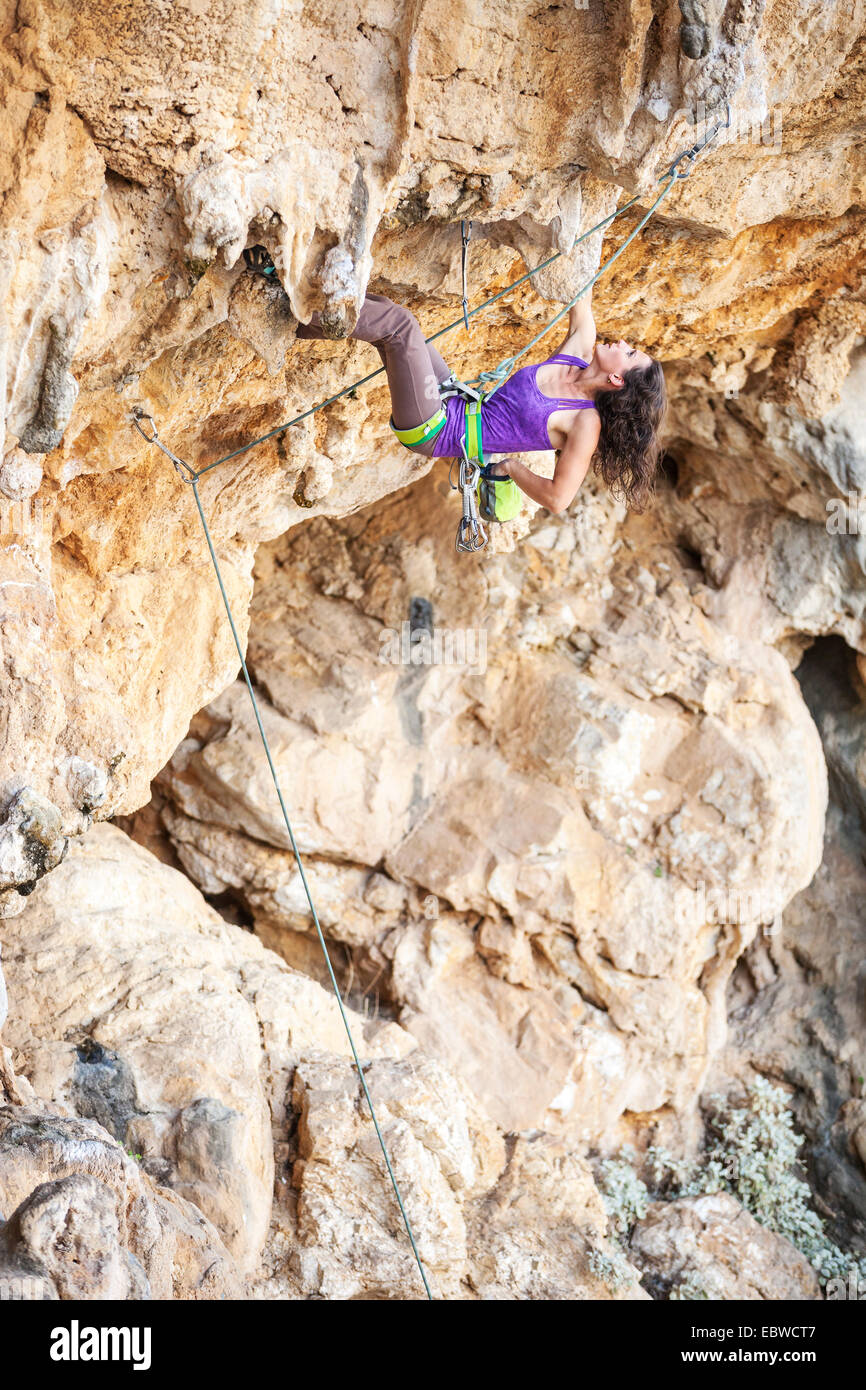 Young female rock climber on a cliff face Stock Photo