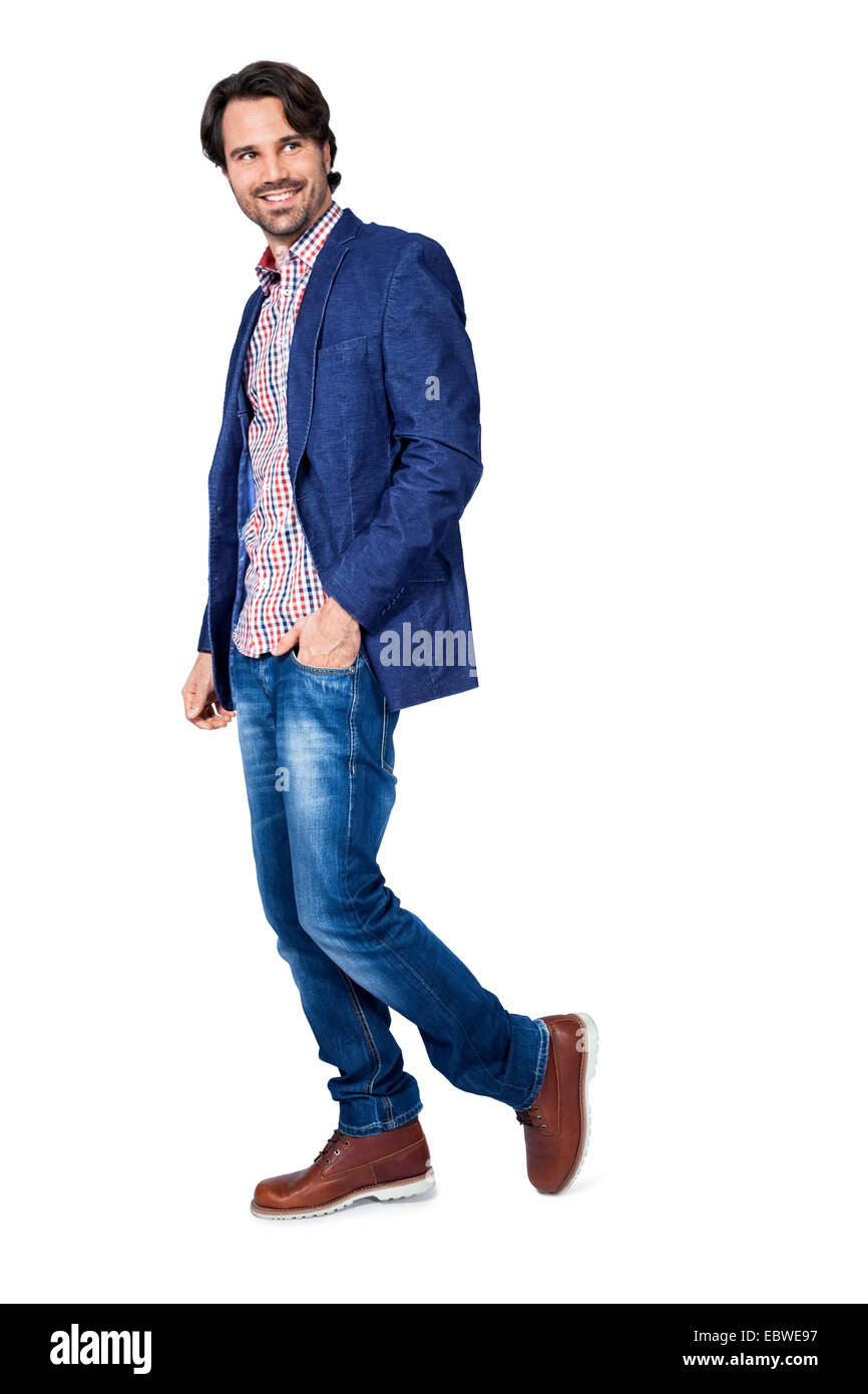 Handsome smiling man in stylish leisurewear approaching the camera in a relaxed posture with his hand in his pocket, isolated on Stock Photo