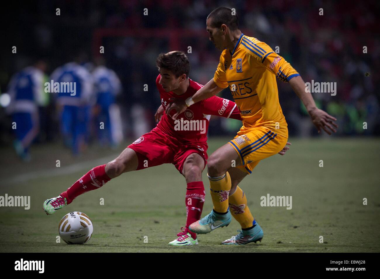 Toluca, Mexico. 4th Dec, 2014. Isaac Brizuela (L) of Toluca vies for the ball with Jorge Torres Nilo of Tigres during their semi-finals match of Opening Tournament of the MX League, at Nemesio Diez Stadium, in Toluca, Mexico State, Mexico, on Dec. 4, 2014. © Alejandro Ayala/Xinhua/Alamy Live News Stock Photo