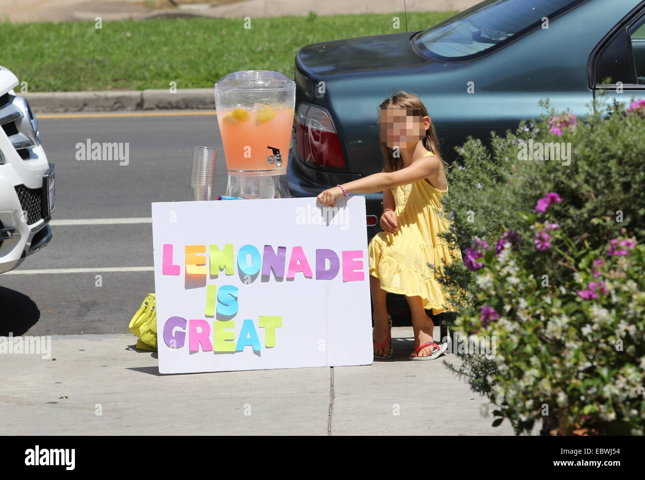 Alessandra Ambrosio watches her daughter Anja sell home made lemonade on a street in Brentwood  Featuring: Anja Mazur Where: Los Angeles, California, United States When: 01 Jun 2014 Stock Photo