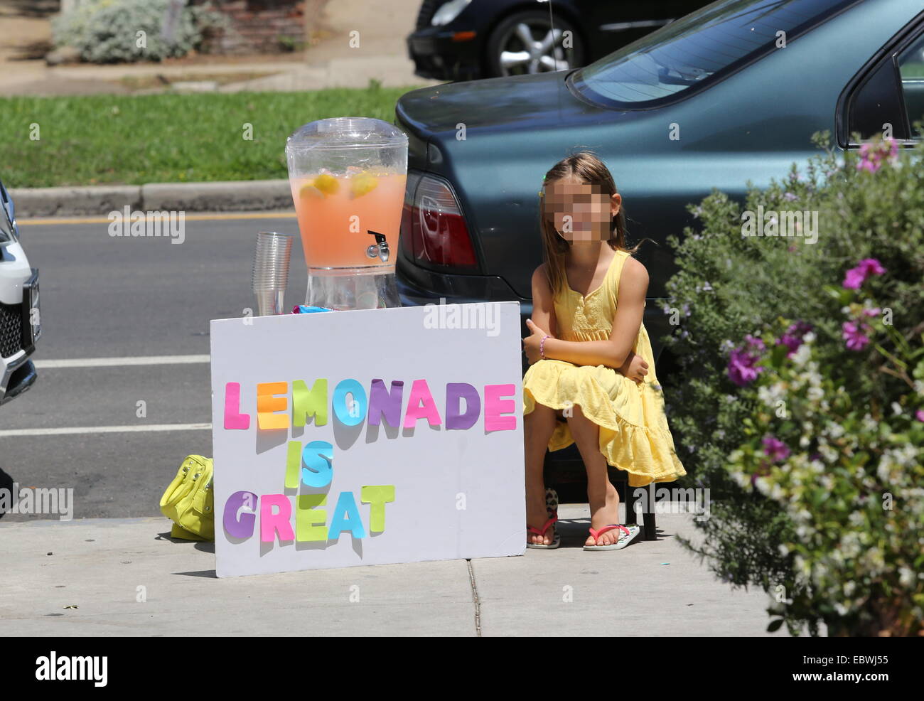 Alessandra Ambrosio watches her daughter Anja sell home made lemonade on a street in Brentwood  Featuring: Anja Mazur Where: Los Angeles, California, United States When: 01 Jun 2014 Stock Photo
