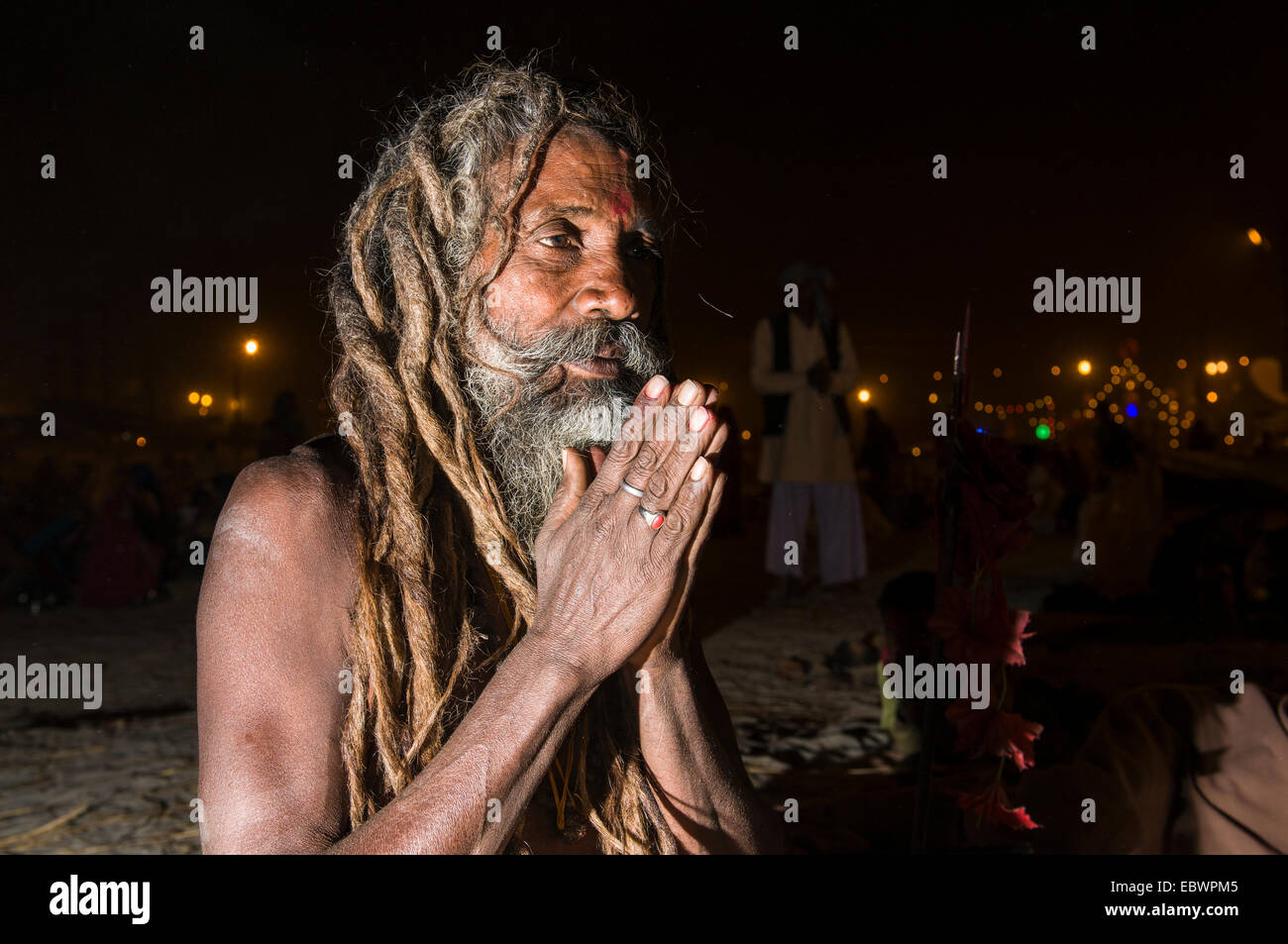 Shiva sadhu, holy man, sitting and praying at night at the Sangam, the confluence of the rivers Ganges, Yamuna and Saraswati Stock Photo