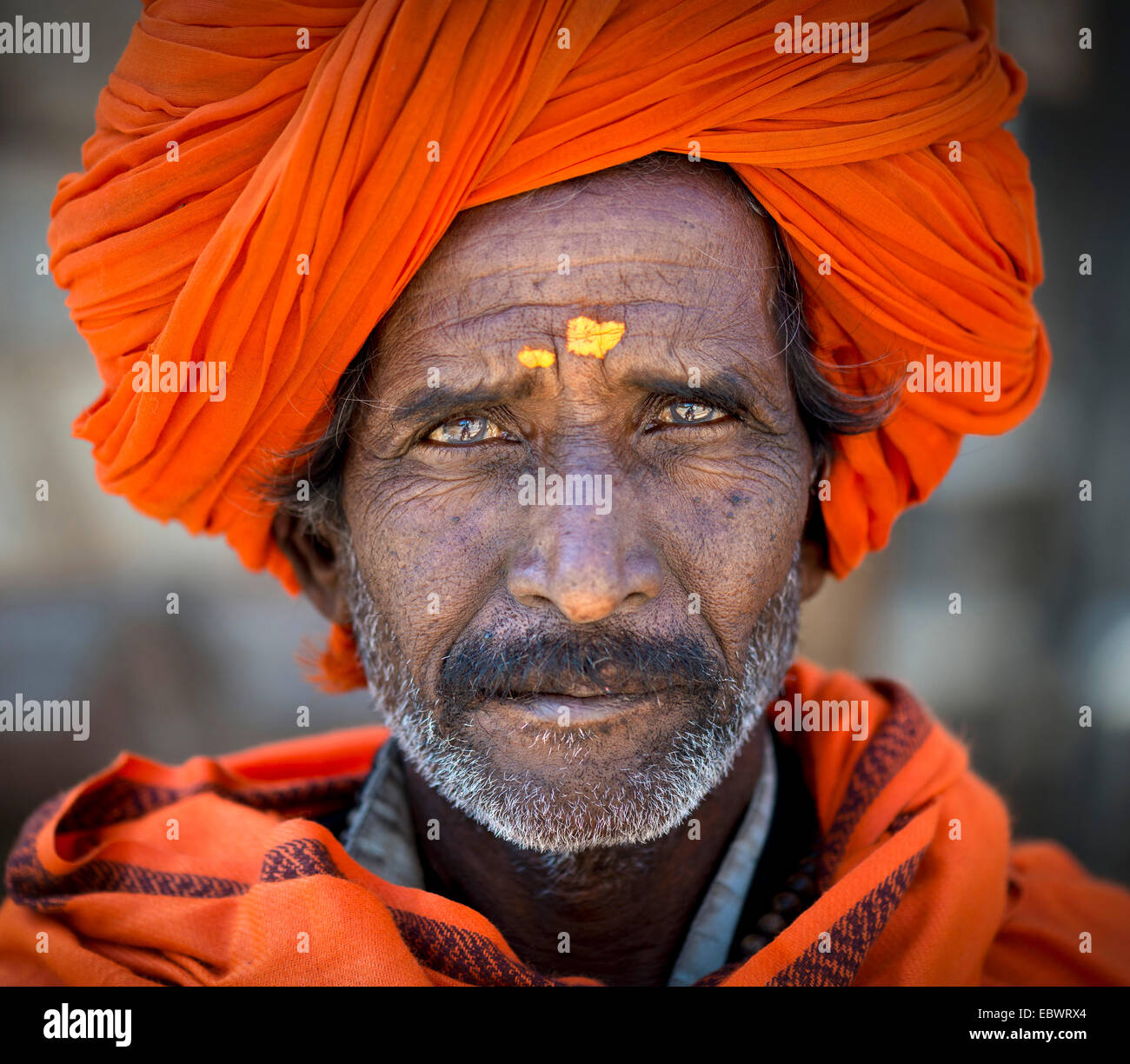 Man with and orange turban and yellow bindi on his forehead, portrait, Chittorgarh Fort, Chittorgarh, Rajasthan, India Stock Photo