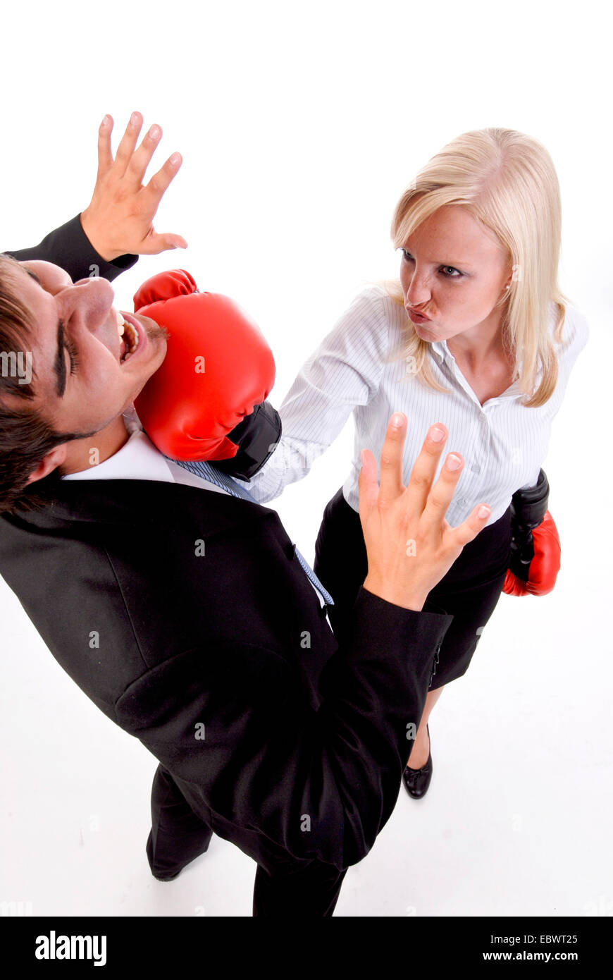 business woman with boxing gloves planting a punch on a businessman's