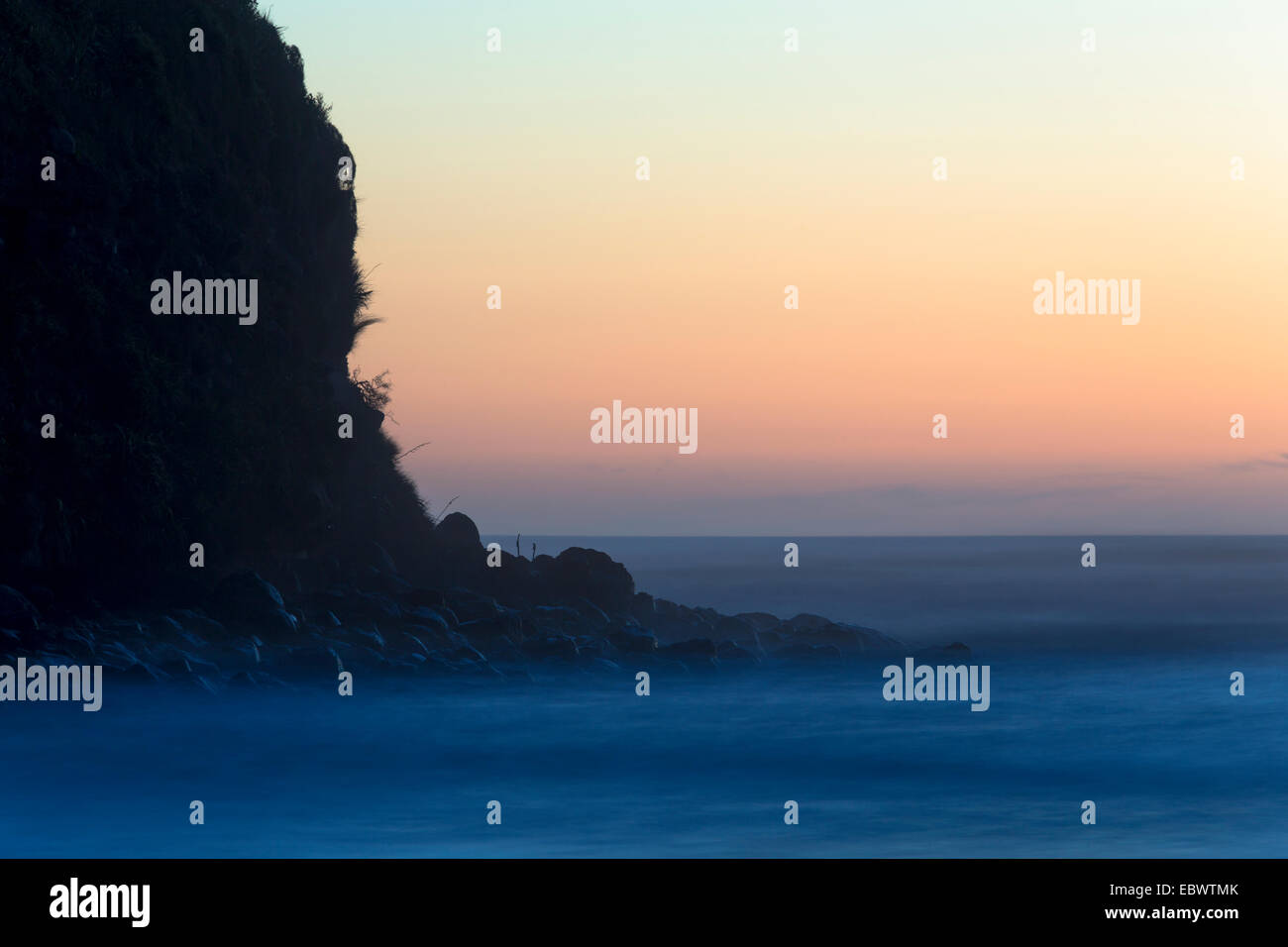 Cliffs and surf after sunset, Opunake, Taranaki Region, New Zealand Stock Photo