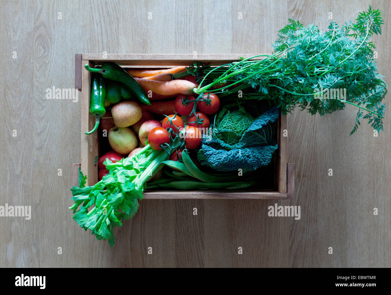Organic vegetables and fruit in a wooden box Stock Photo