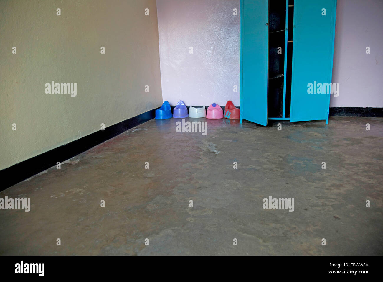 row of plastic potties in the corner of an empty room in an orphanage, Burundi, Bujumbura Mairie, Bujumbura Stock Photo