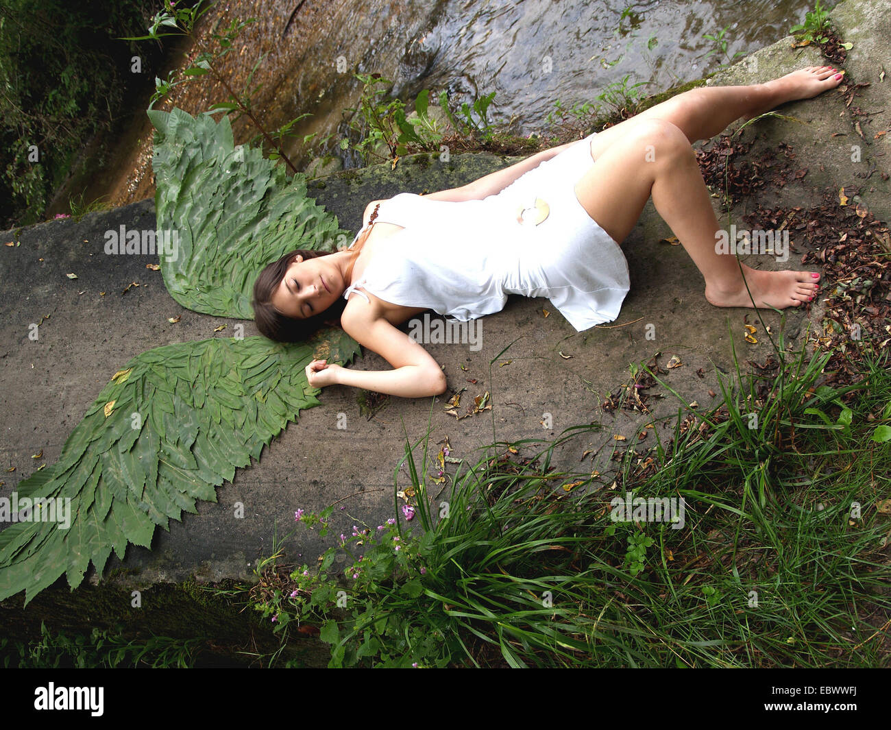 Overhead view of a young woman lying with fairy wings Stock Photo
