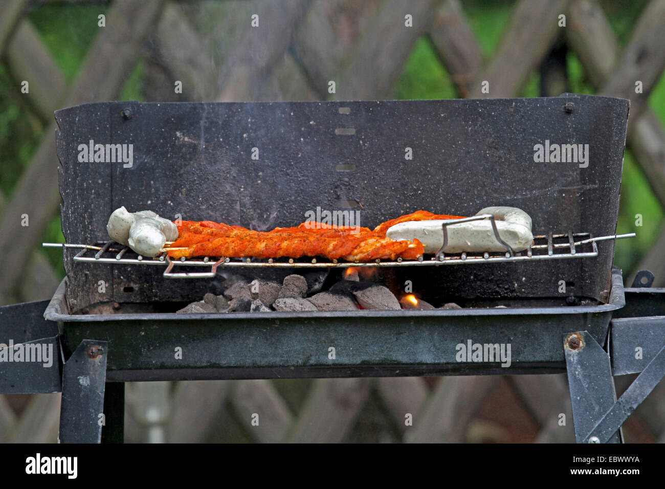 grill meat on a customary charcoal grill, Germany Stock Photo