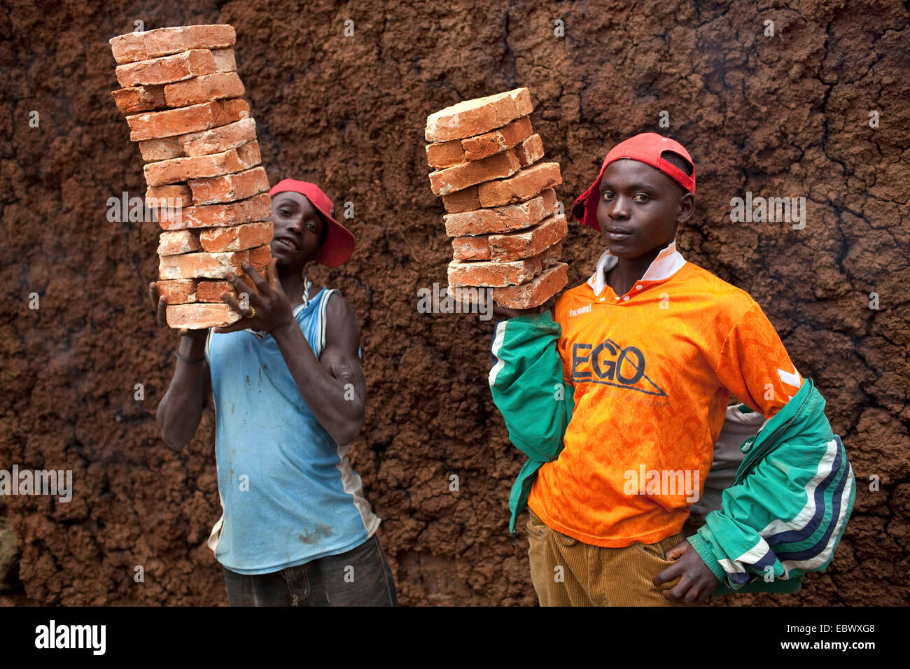 two young men carrying stack of bricks, Burundi, Karuzi, Buhiga Stock Photo