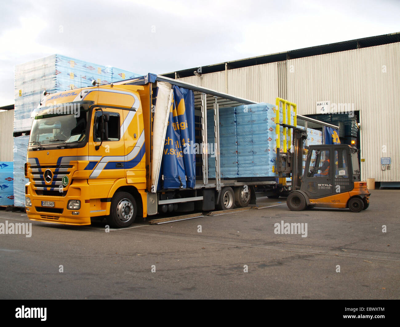 truck being loaded by a forklift in front of a goods depot Stock Photo