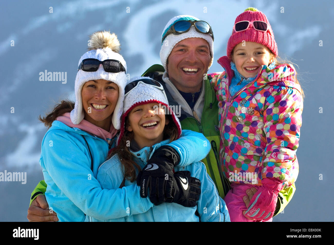 group photo of a family of four in winter clothing during holidays in the mountains, France Stock Photo