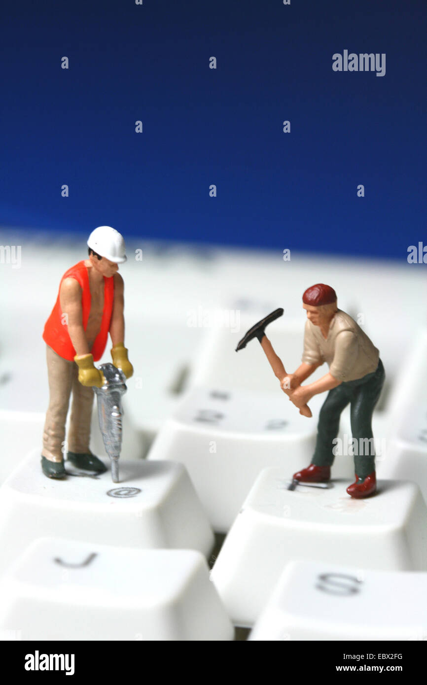 Construction workers on computer-keyboard Stock Photo