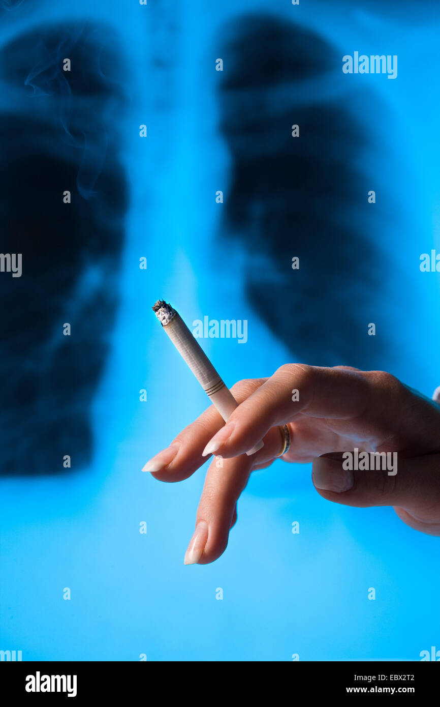 woman smoking a cigarette, .X-ray photograph of a lungs in the background Stock Photo