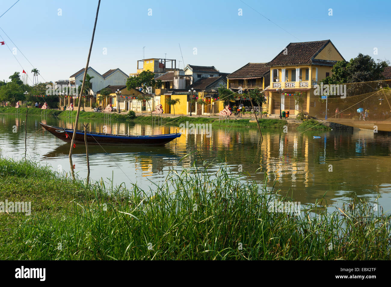 River scene of Hoi An in Vietnam with traditional fishing boat. Stock Photo