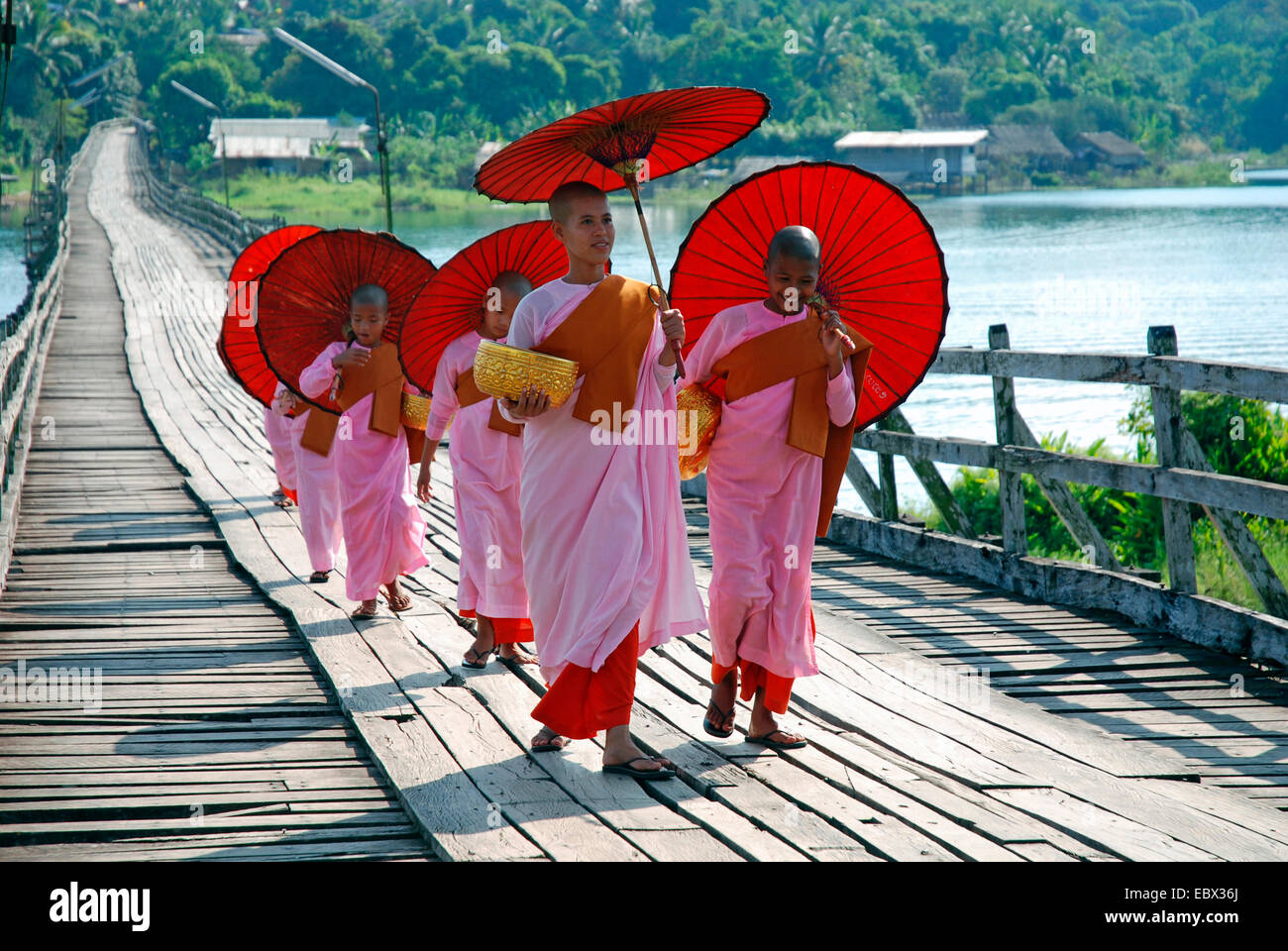 a group of nuns and convent pupils with sunshades on a wooden bridge, Thailand, Sanglaburi Stock Photo