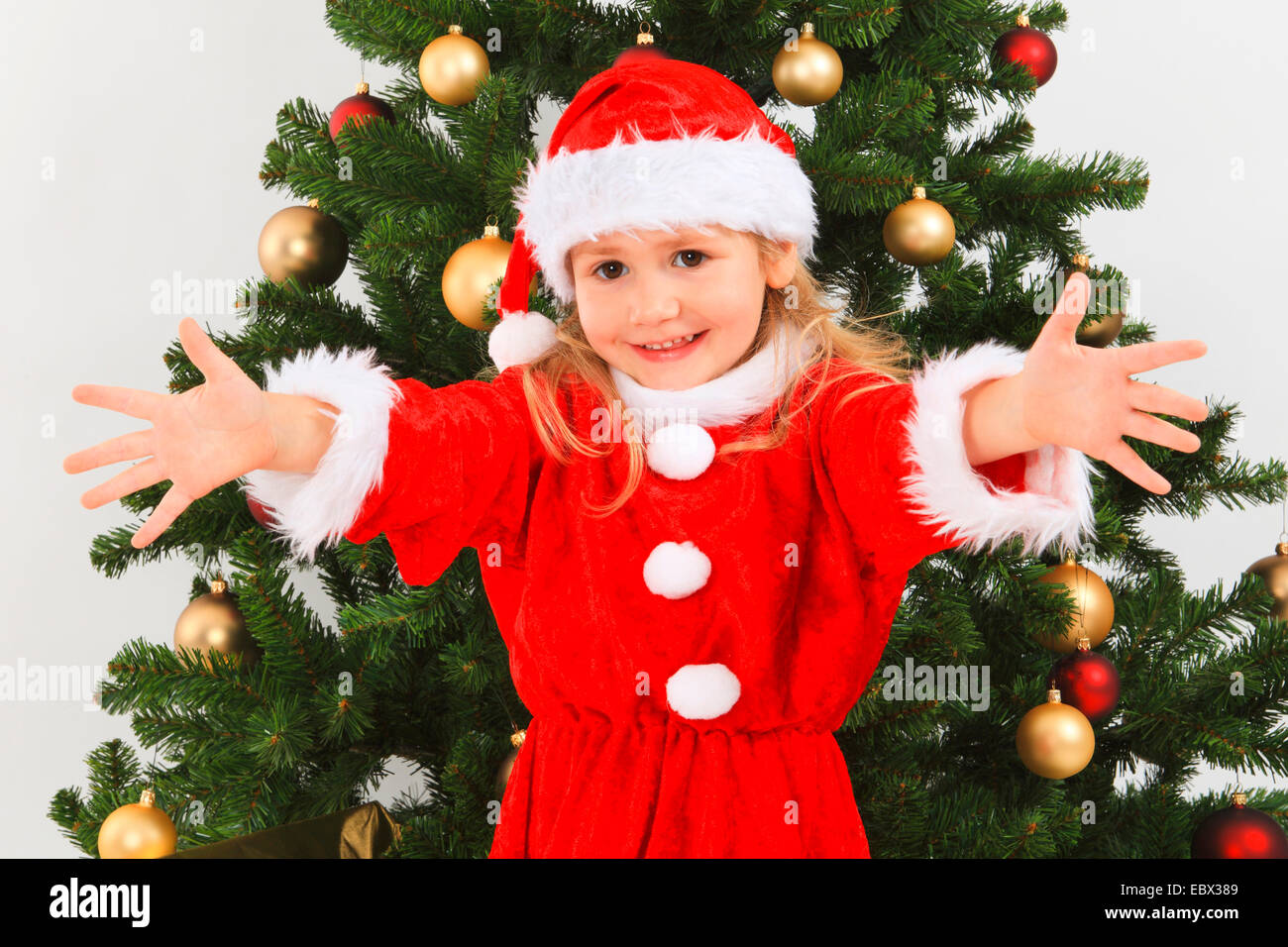 little girl dressed up as Santa Claus with a christmas tree, Switzerland Stock Photo