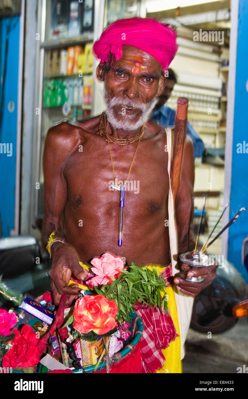 old Hindu with joss sticks in one and a bag full of flowers in the other hand, India, Andaman Islands Stock Photo