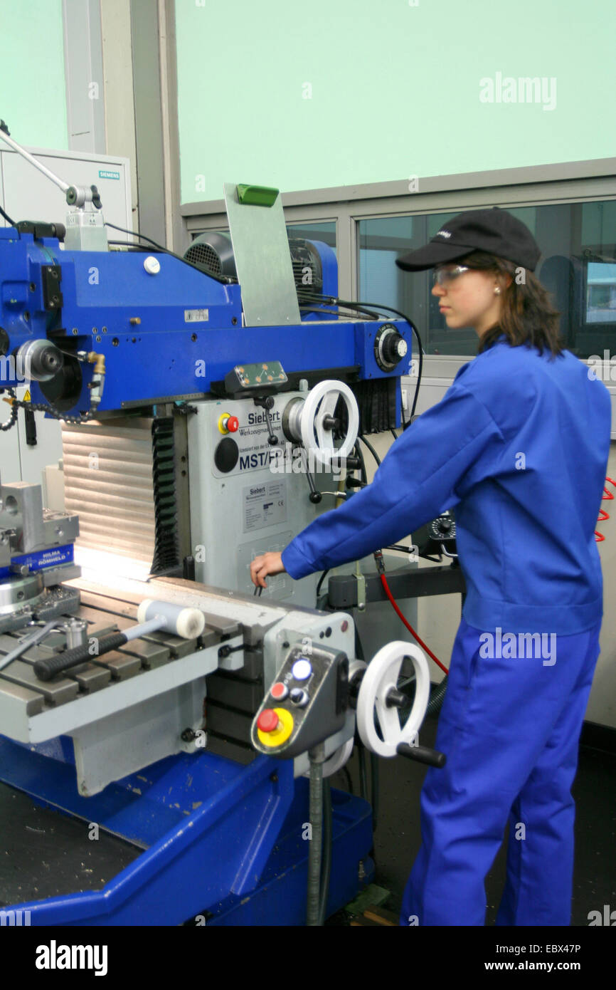 female apprentice working with machine Stock Photo