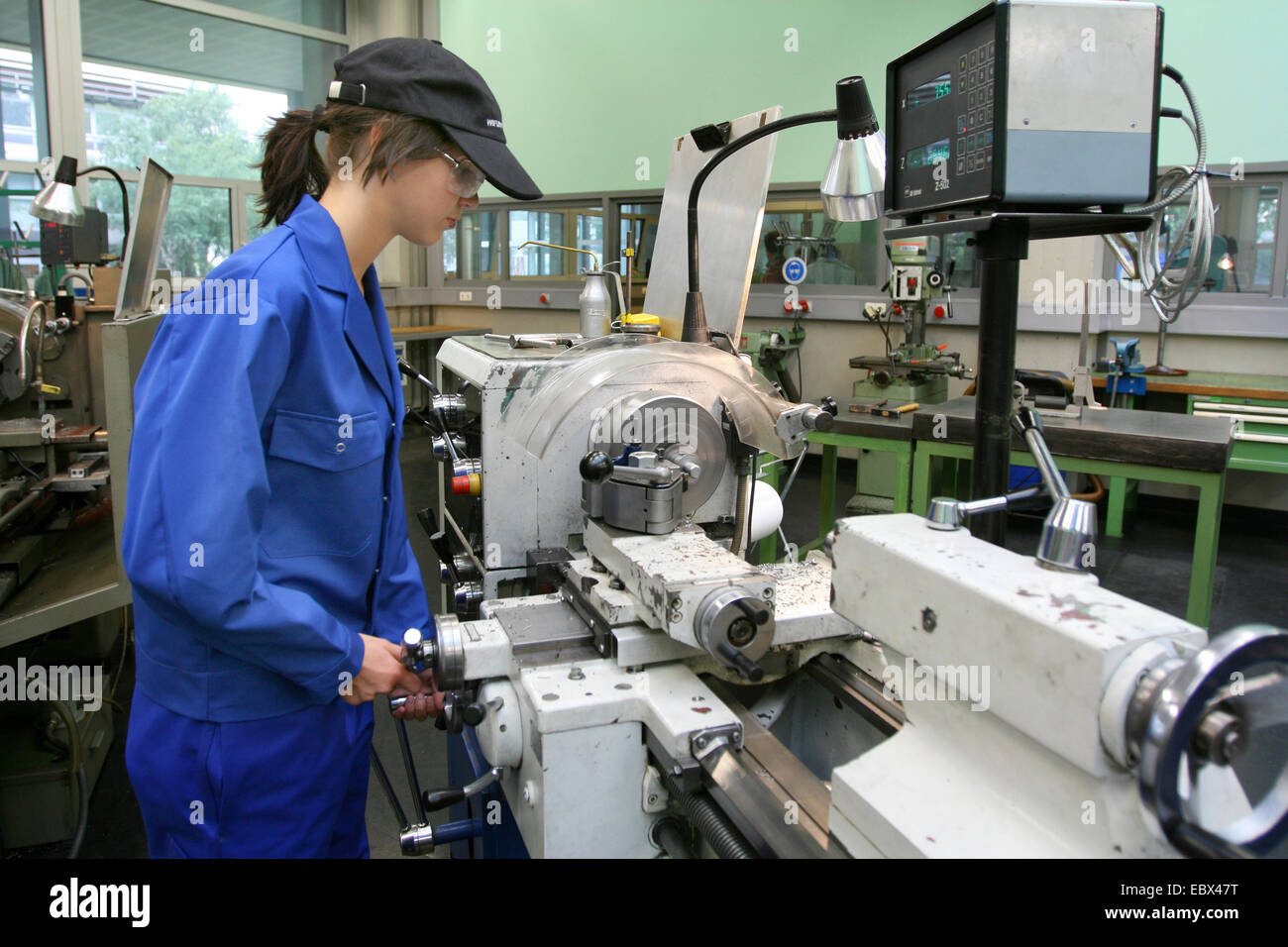 female apprentice working with machines Stock Photo