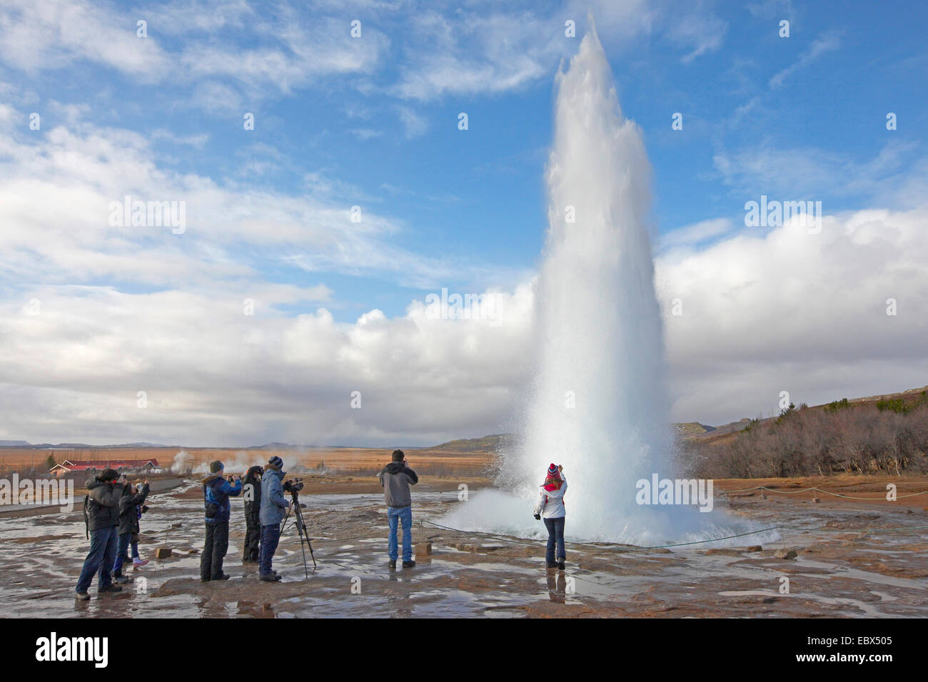 visitors taking pictures at the erupting geysir Strokkur in winter, Iceland, Suedwest Island Stock Photo
