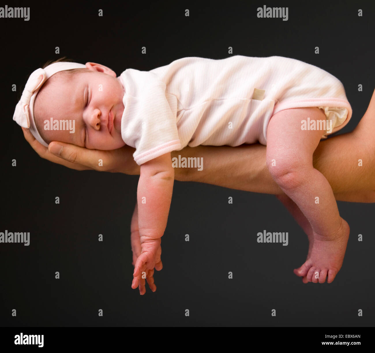 Supporting Hands. Father holding his 14 days old baby girl on his arms