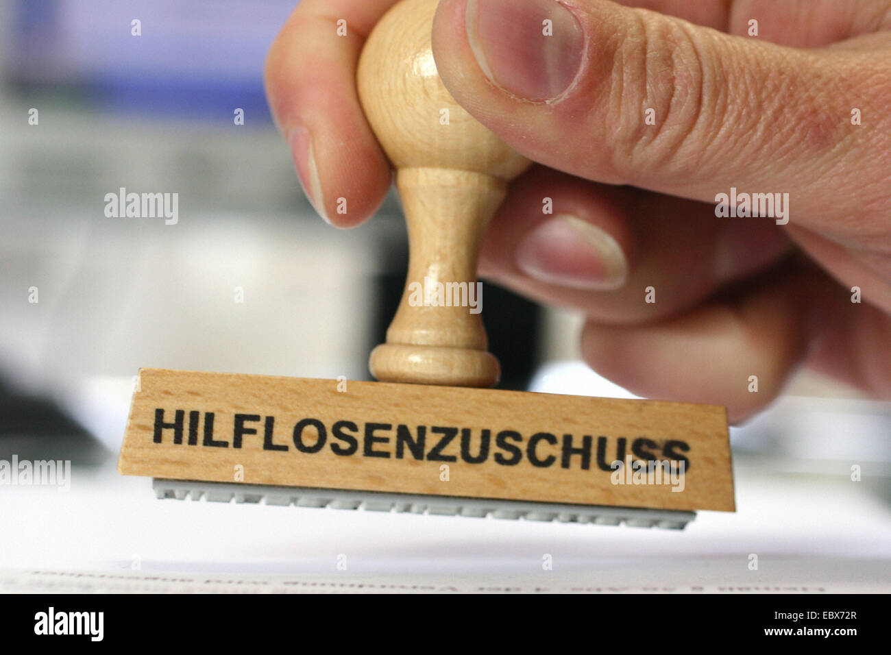 hand with a stamp Hilflosenzuschuss, helpless subsidy Stock Photo