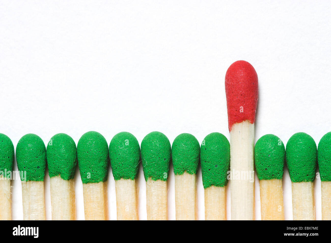 one big red matchstick amongst green ones Stock Photo