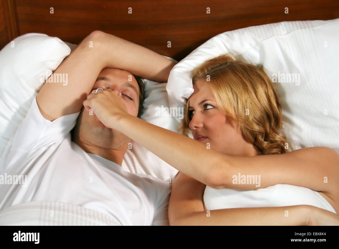 snoring man and his enervated woman, holding his nose Stock Photo