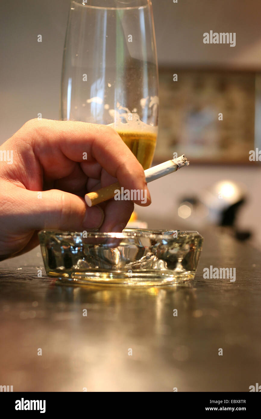 hand holding a cigarette and beer glass Stock Photo
