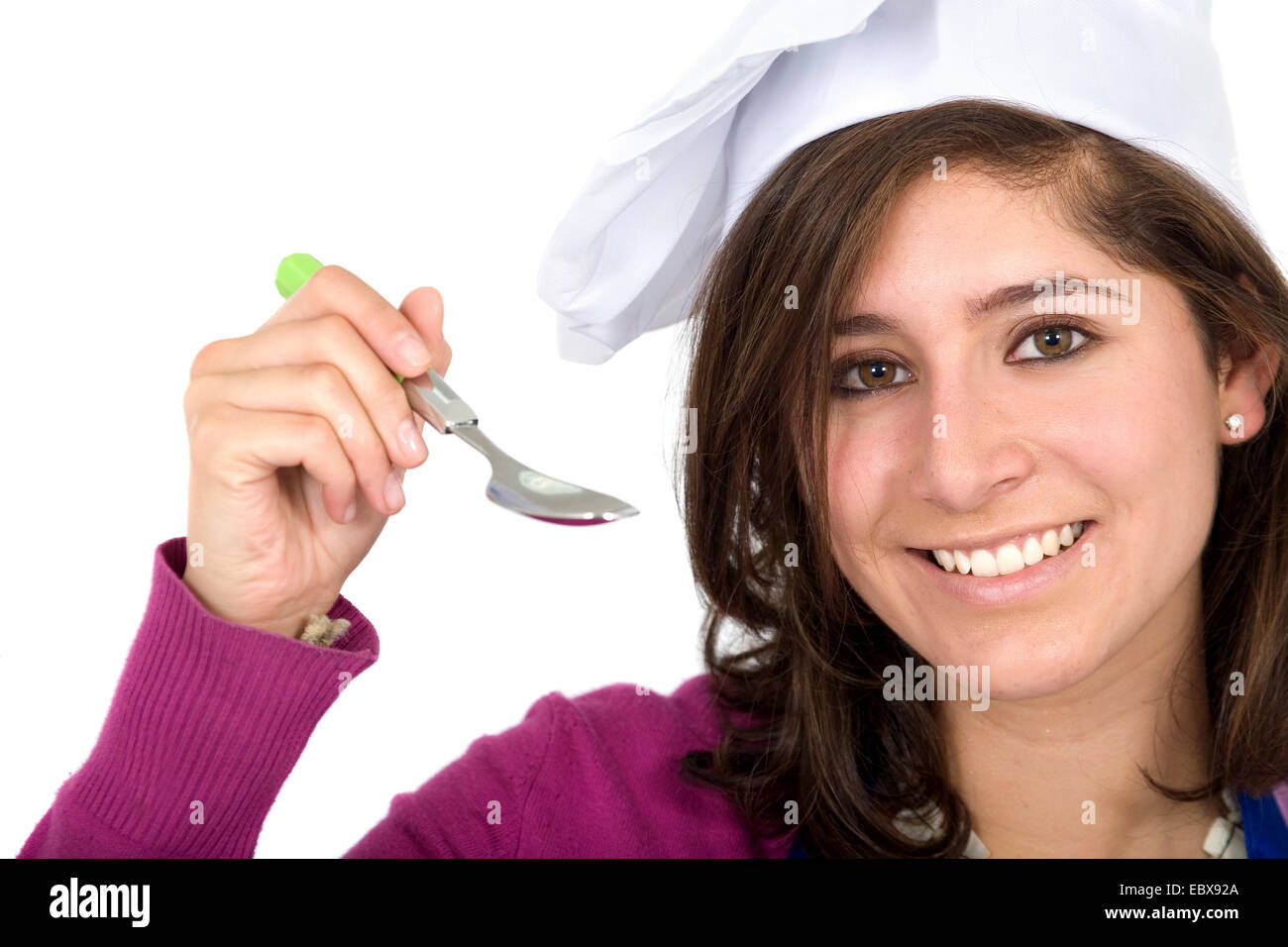 female chef with a spoon tasting her meal Stock Photo