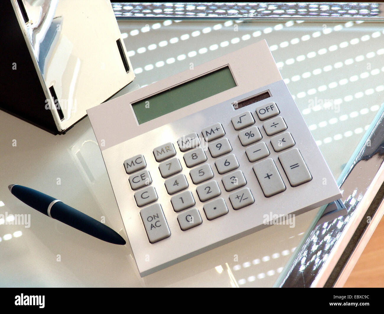 calculator and ball pen on a writing desk Stock Photo